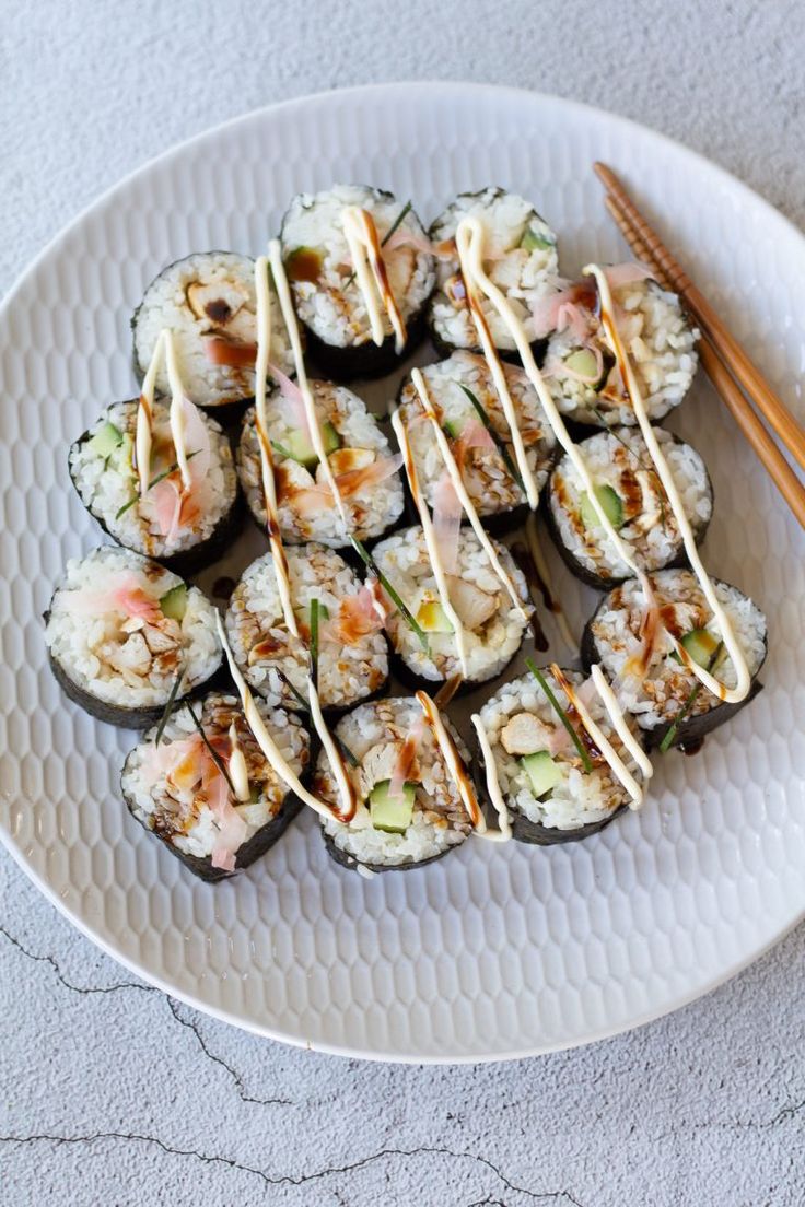 sushi on a plate with chopsticks next to it