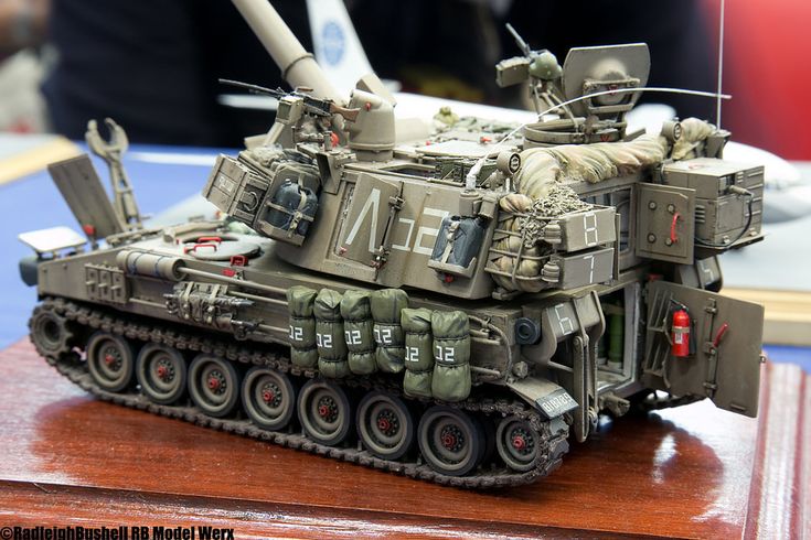 a toy army tank sitting on top of a wooden table