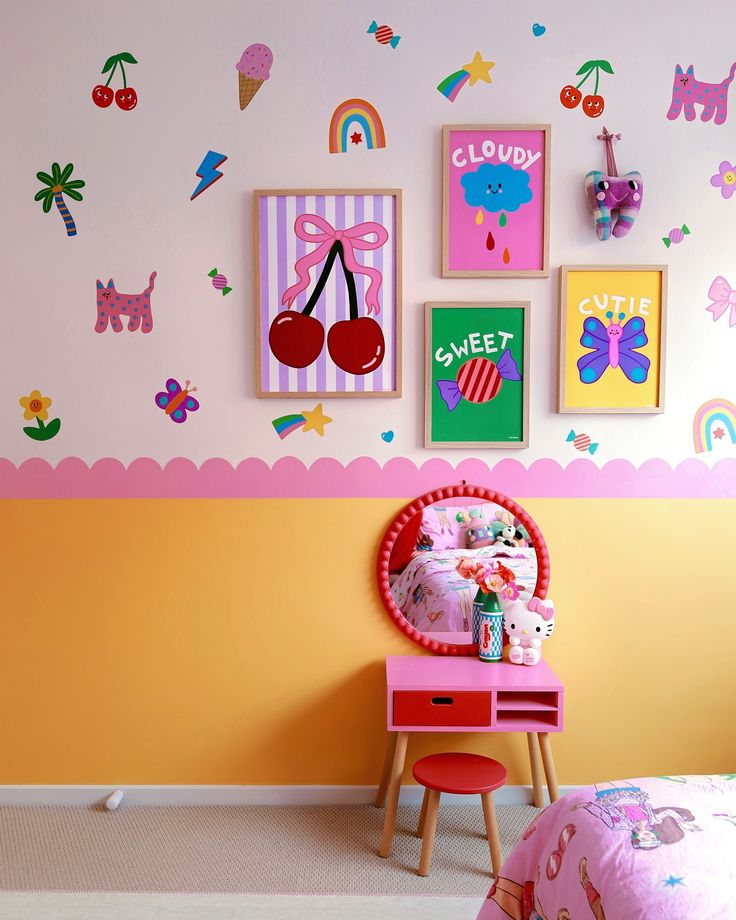 a child's bedroom decorated in pink, yellow and orange with pictures on the wall