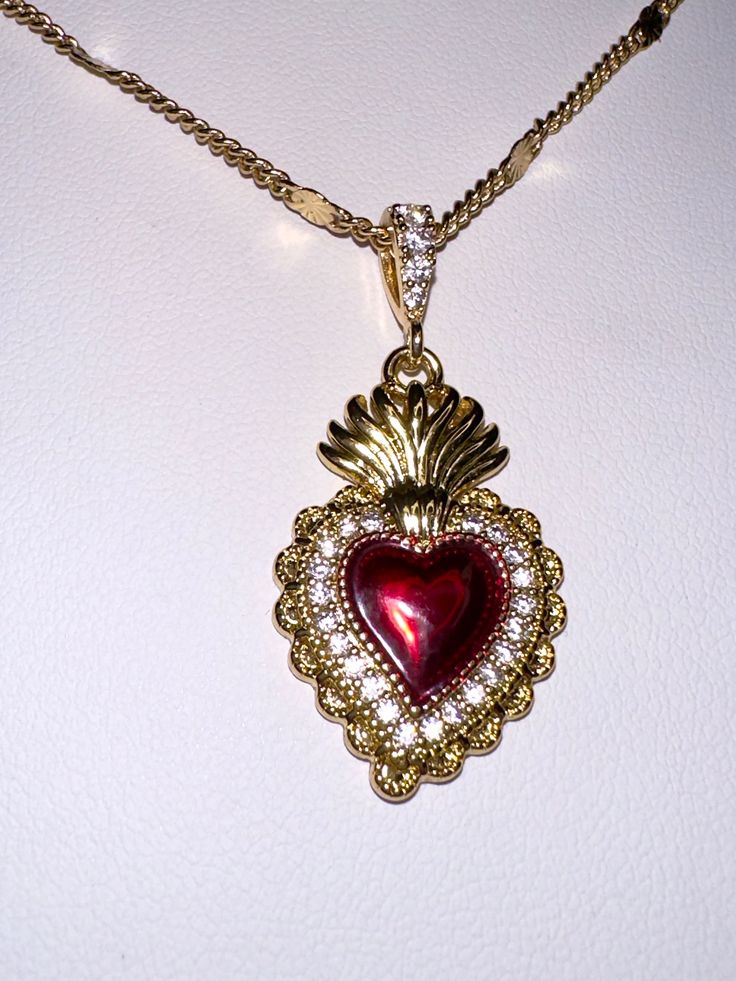 A beautiful 14k gold and red enamel sacred heart necklace on a 14k gold filled curb chain. Featuring cubic zirconia pave detailing on the pendant.Chain length: 17.5 Inch Gothic Vintage Jewelry, Fire Heart Necklace, Luxury Antique Necklaces With Heart Charm, Luxury Vintage Red Necklaces, Sacred Heart Dangle Earrings, Red Jewel Necklace, Sacred Heart Earrings, Sacred Heart Jewelry, Ruby And Gold Jewelry