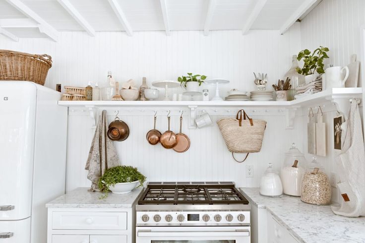 a stove top oven sitting inside of a kitchen next to white cabinets and counter tops