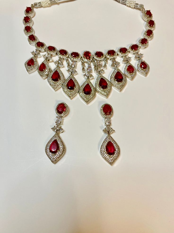 Enhance your special occasion look with our CZ American Diamond Necklace. Perfect for weddings, parties, or as a gift. Its red stones add a touch of elegance to any outfit, such as a saree, gown, or lehanga. Elevate your style with this stunning accessory. This jewellery set includes a necklace and matching earrings. Jewellery Care- Keep the jewellery dry, avoid contact with perfumes and water. American Diamond Necklaces, Saree Gown, Bridal Choker, Red Stones, A Necklace, Jewellery Set, American Diamond, Red Stone, Bridal Sets