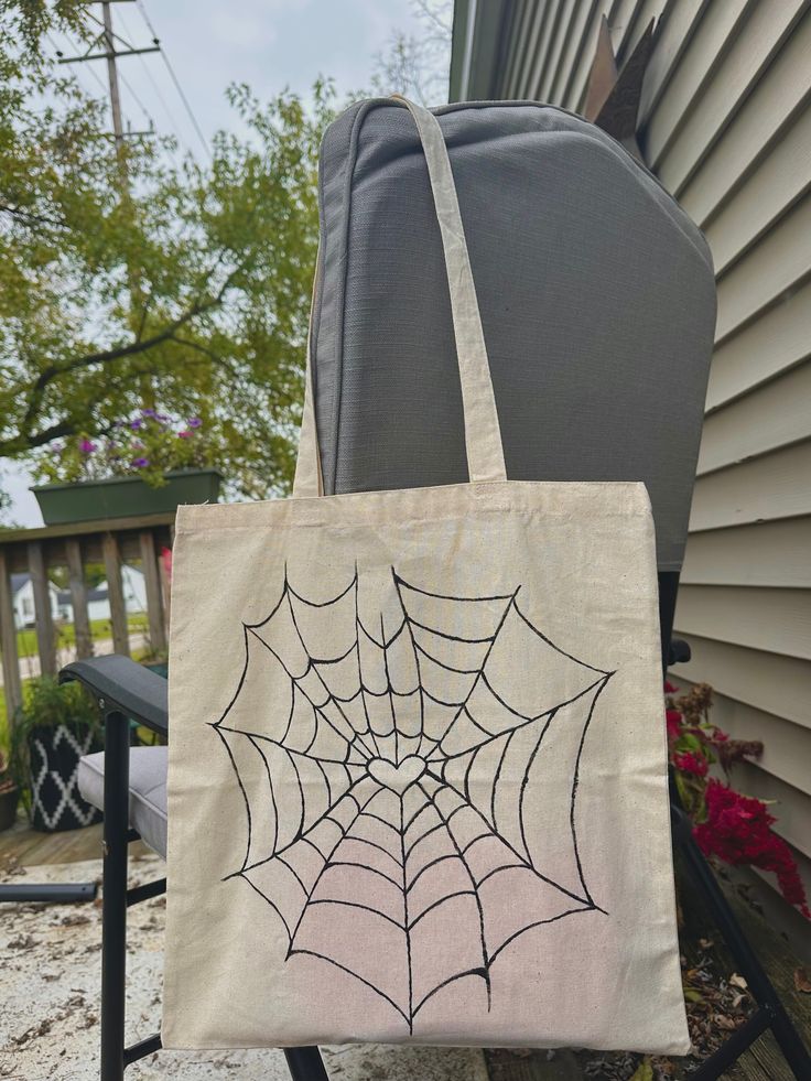 a spider web tote bag sitting on top of a chair