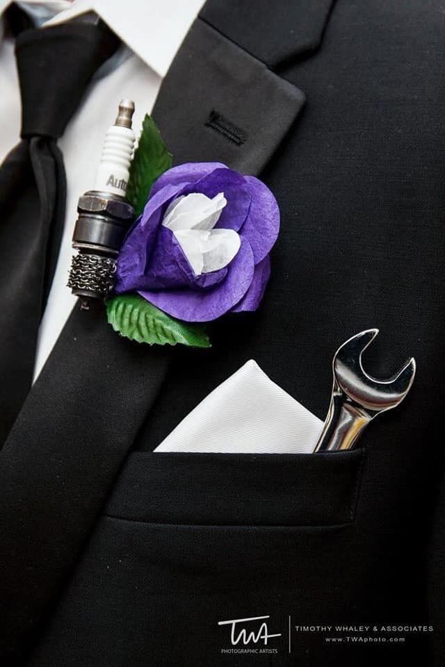 a man wearing a suit and tie with a purple flower on it's lapel