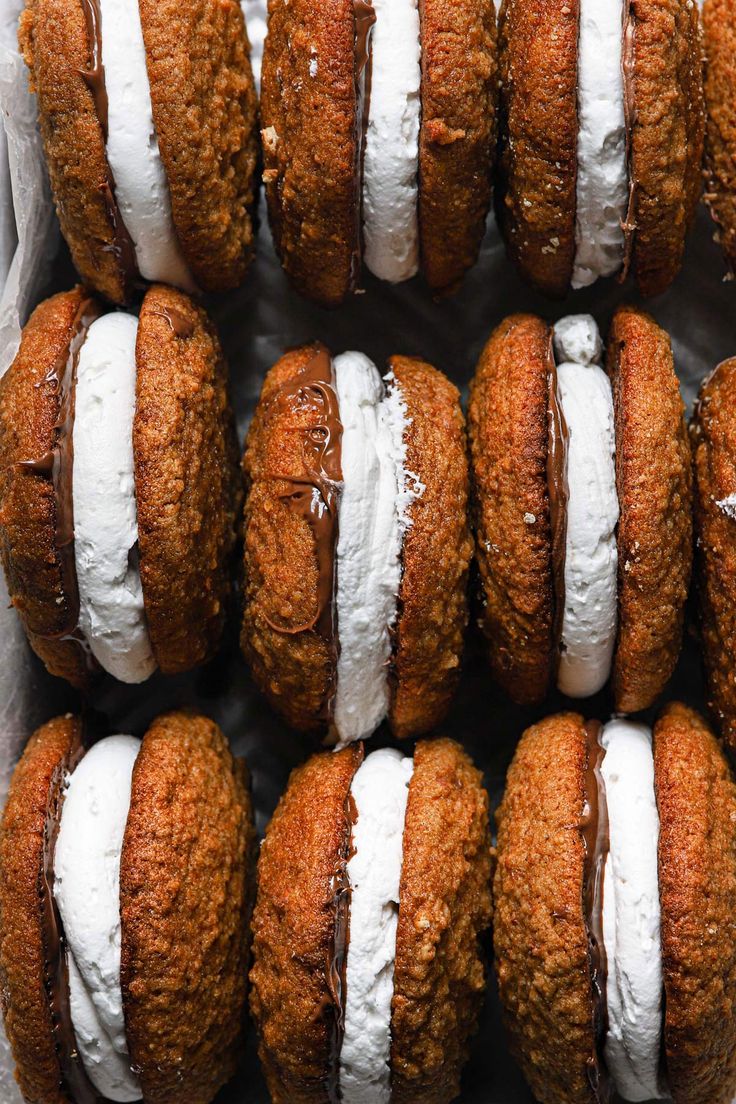 there are some cookies with white frosting on them and the words s'mores whoopie pies