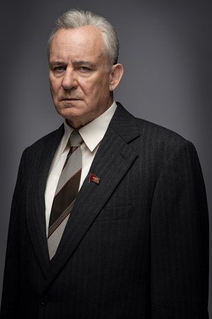 an older man wearing a suit and tie