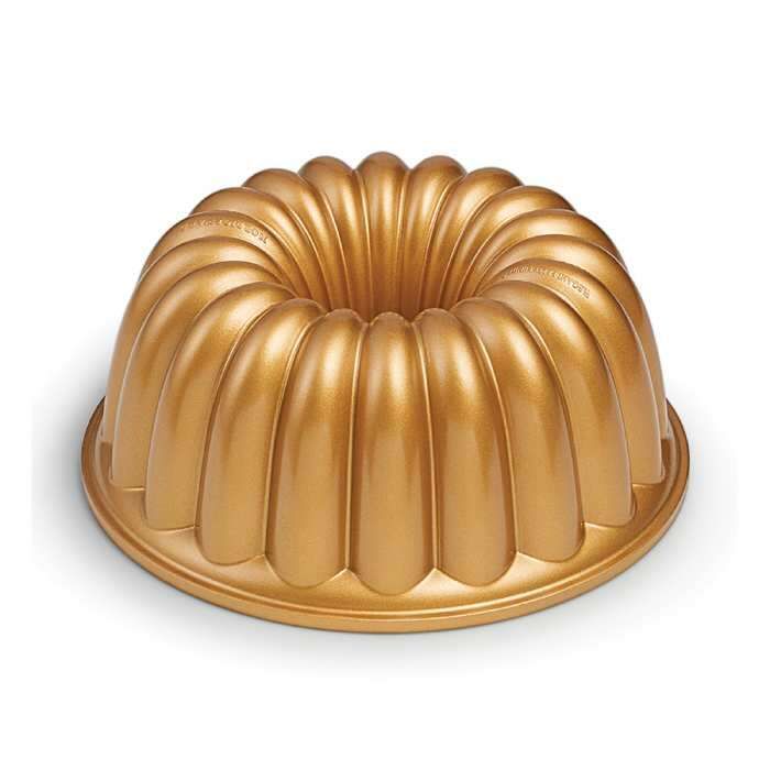 a gold bundt cake on a white background