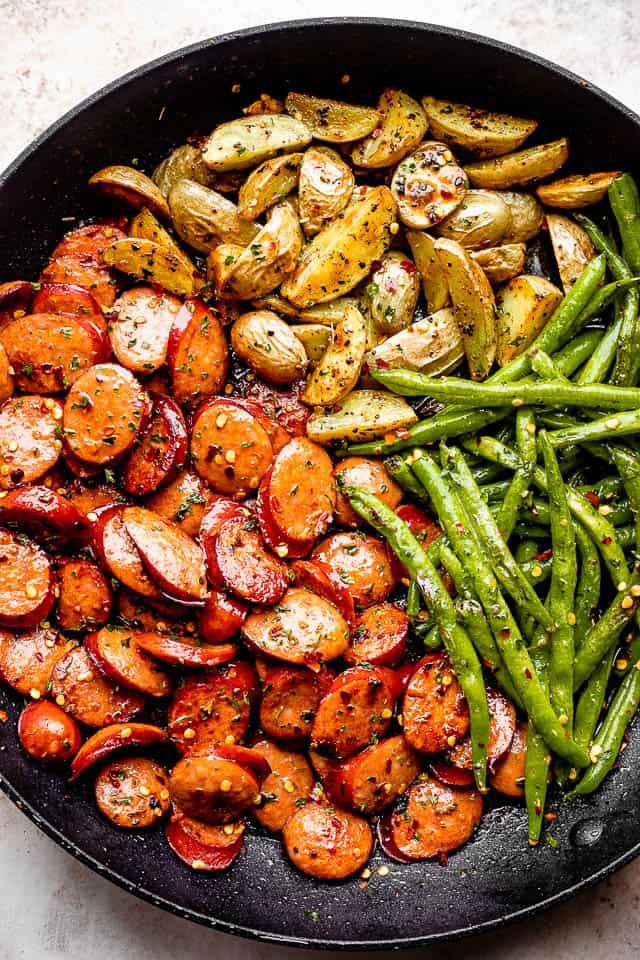 a skillet filled with potatoes and green beans