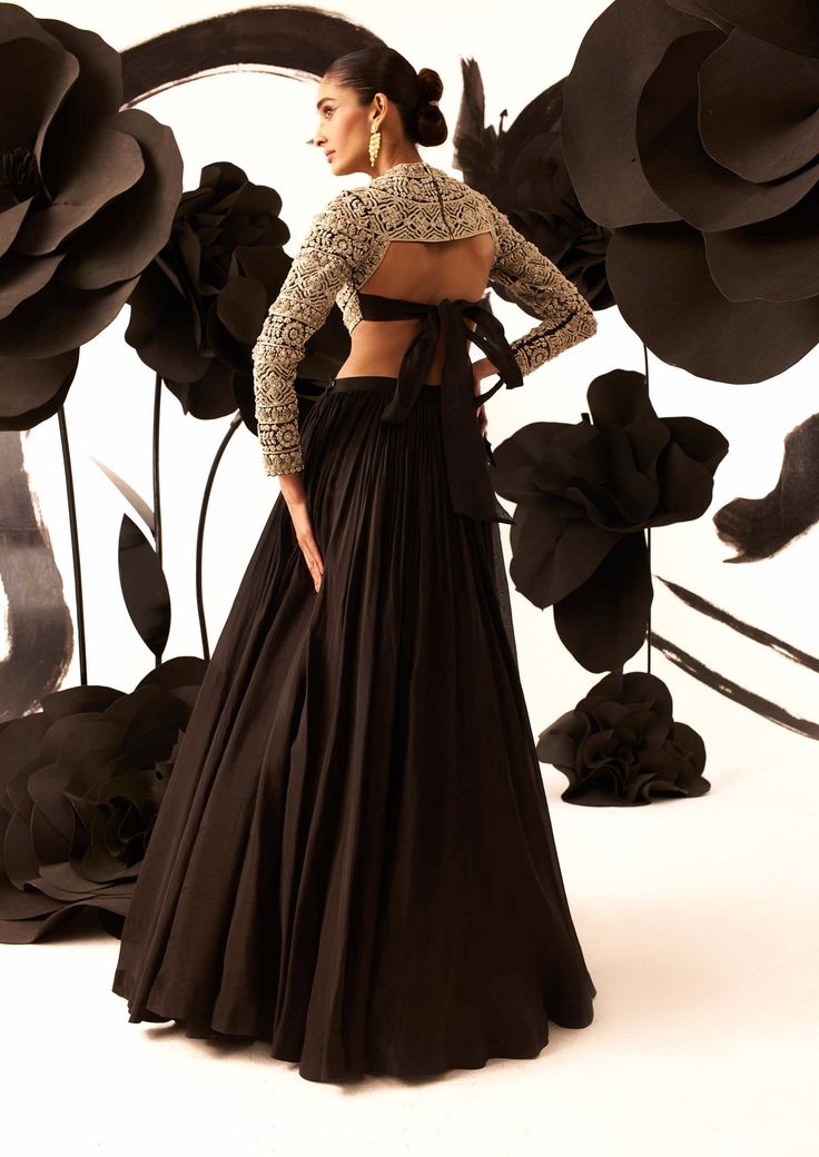 Make a bold statement with a black heavy floral embroidery blouse featuring a back bow, paired seamlessly with a black organza skirt. This ensemble exudes modern elegance and is perfect for making a sophisticated impact at any special occasion. Black Blouse Designs For Navratri, Embroidery Stones, Floral Embroidery Blouse, Bhumika Sharma, Black Blouse Designs, Black Embroidered Blouse, Long Blouse Designs, Indian Bridesmaid Dresses, Net Embroidery