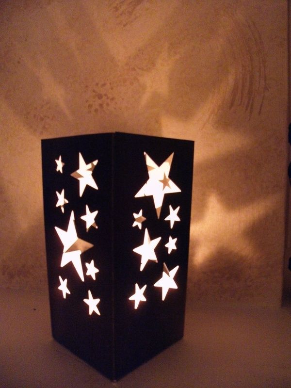 a lit up box with white stars on the front and sides, sitting on a table