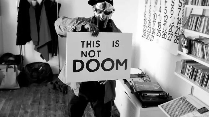 a man holding a sign that says, this is not doom in front of him