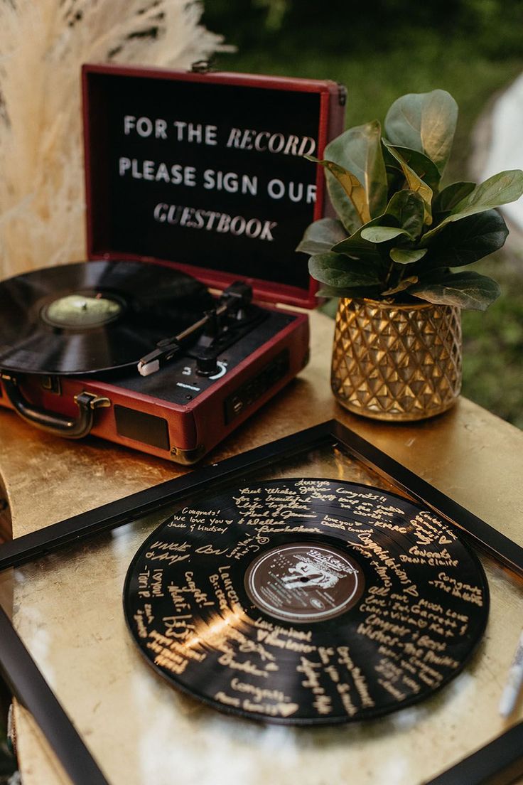 a record player sitting on top of a table next to a potted plant