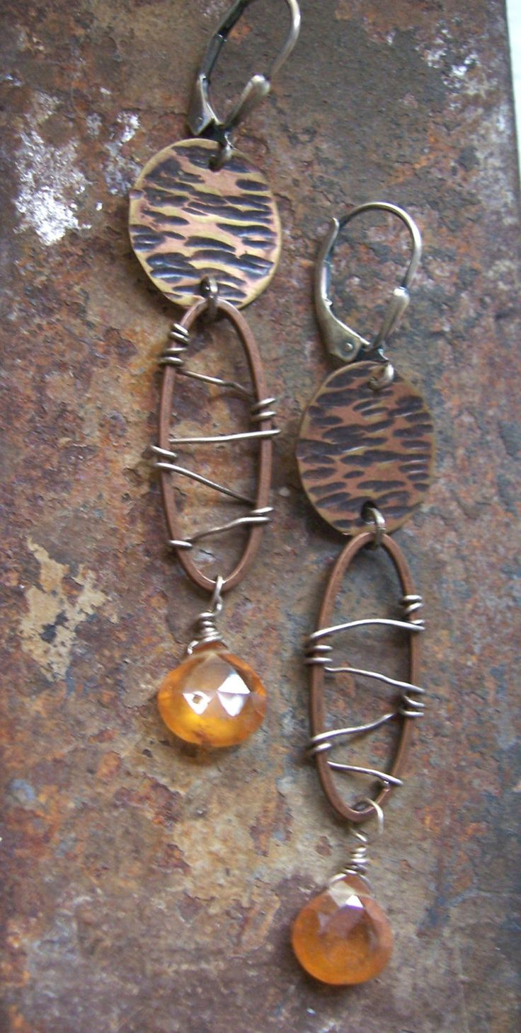 Rustic. Contemporary. Edgy. These organic copper dangle earrings shine by combining sterling silver and copper with beautiful mandarin garnet. The copper disc is oxidized, pierced and textured. Sterling silver wire is woven inside a copper oval shape to add a rusty worn appearance mimicking barbed wire. The vibe is steampunk with an added burst of color. The earrings are 2' long and are hung from sterling leverbacks for safety. They come in a gift box, perfect for giving or just safe keeping. Artisan Rust-colored Nickel-free Jewelry, Artisan Metal Earrings In Rust Color, Artisan Metal Rust Earrings, Unique Rust-colored Earrings With Ear Wire, Rust Dangle Earrings With Ear Wire, Handmade Rust Metal Earrings, Rust Color Dangle Earrings With Ear Wire, Handmade Rust-colored Metal Earrings, Unique Rust Earrings With Ear Wire