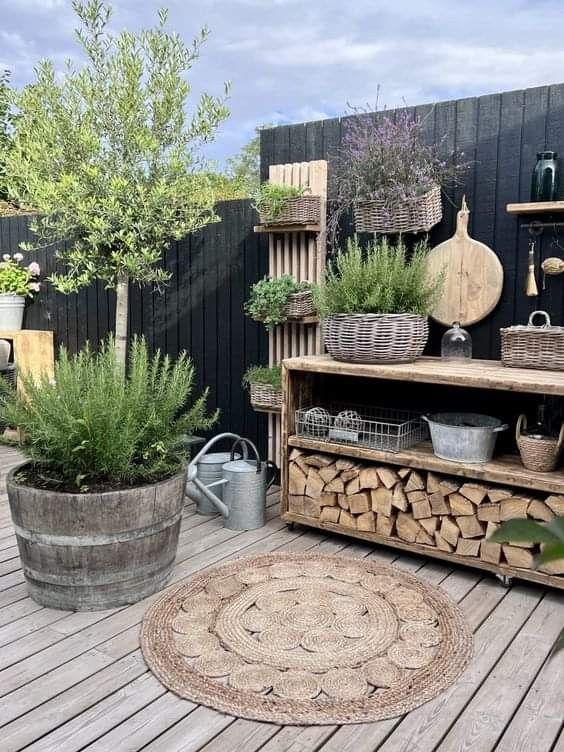 a wooden deck with potted plants and other items on the shelves next to it