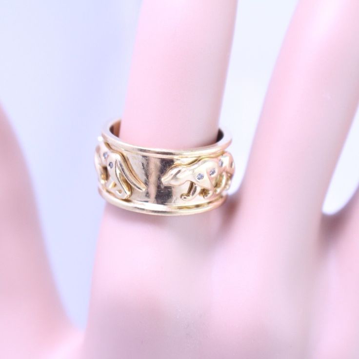 a close up of a person's hand with a gold ring on it