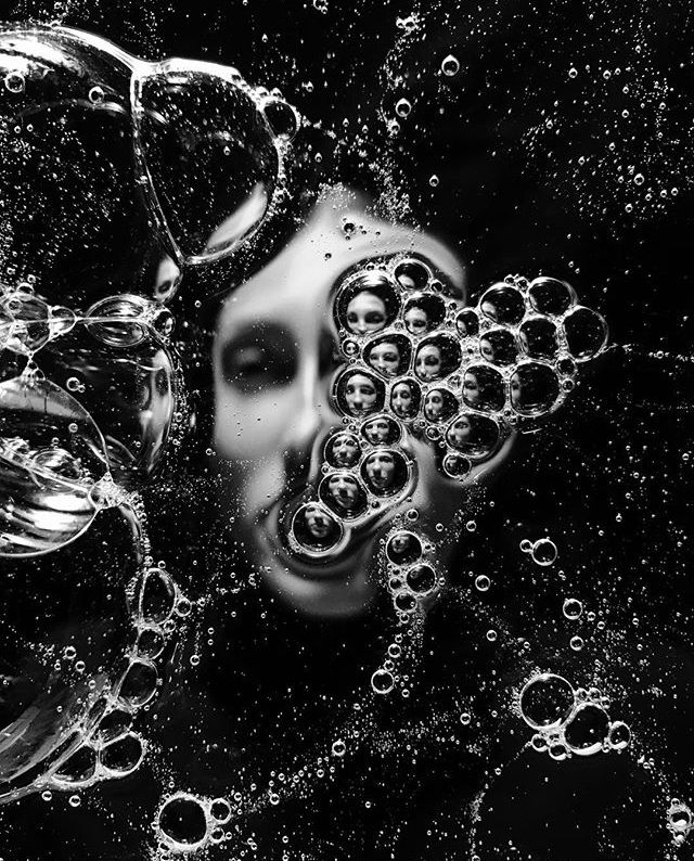 black and white photograph of bubbles in water with an abstract face on the right side