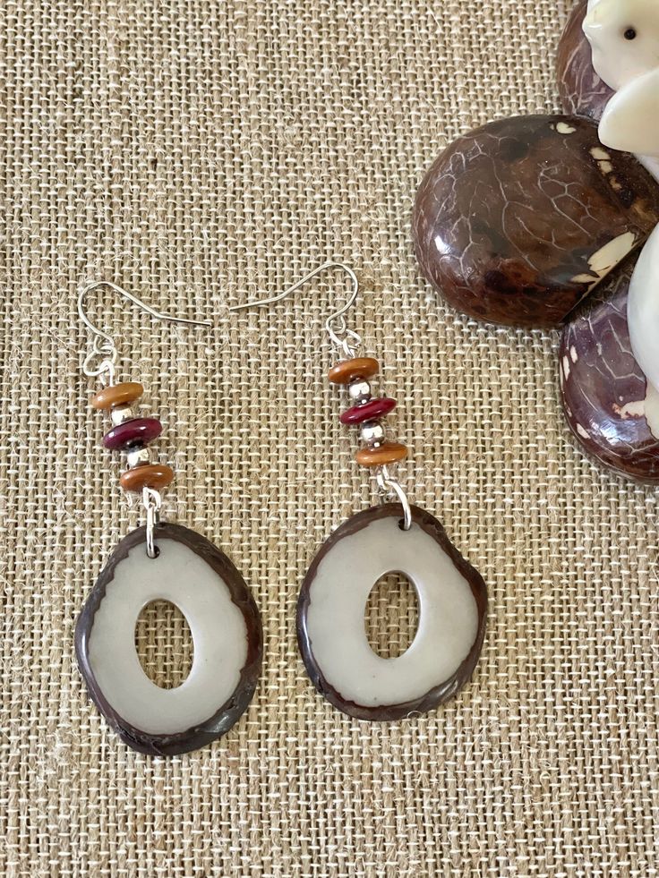 Handmade in Ecuador Earrings Length: 2.5 Inches Material: Tagua Nut Due to this item being handmade and the nature of the Tagua Nut the size and the color may vary from piece to piece Nature-inspired Brown Jewelry With Matching Earrings, Handmade Brown Nature-inspired Earrings, Brown Dangle Earrings Nature-inspired, Nature-inspired Brown Earrings With Ear Wire, Nature-inspired Dangle Jewelry In Natural Color, Unique Brown Earrings For Beach, Nature-inspired Brown Dangle Earrings, Nature-inspired Brown Jewelry With Natural Variations, Nature-inspired Natural Color Dangle Jewelry