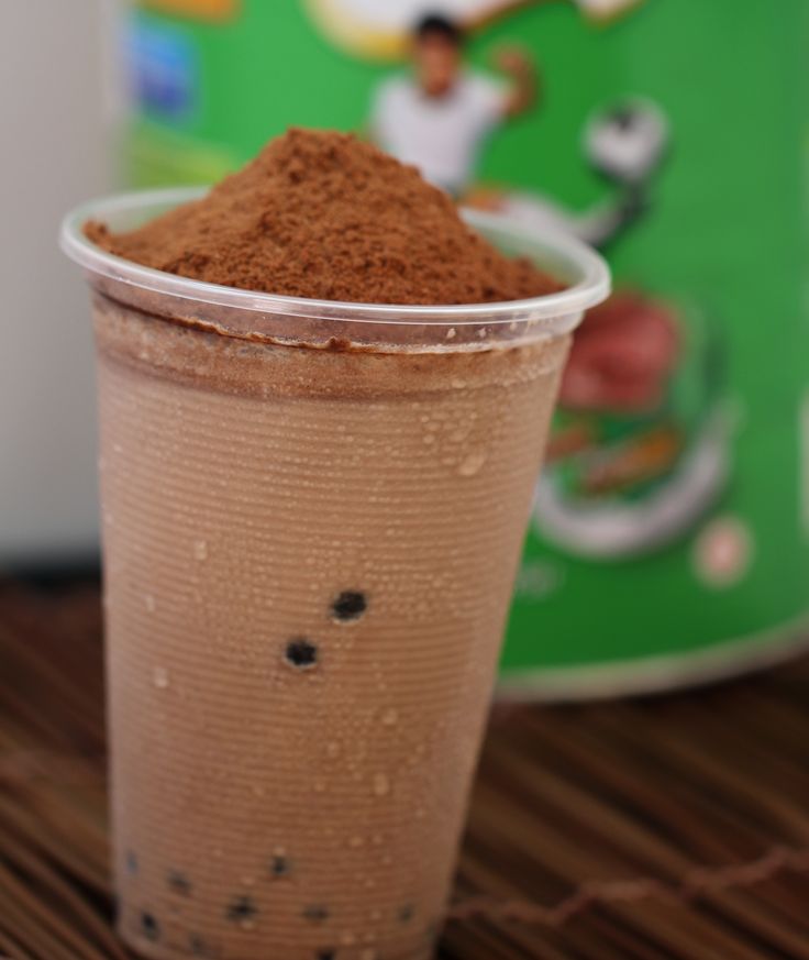 a close up of a cup of coffee with some kind of powder in it on a table