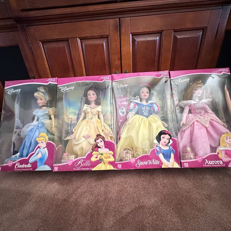 four disney princess dolls in boxes on the floor