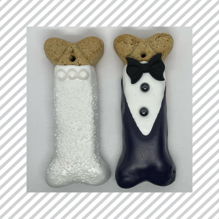 two decorated cookies in the shape of dogs wearing tuxedo and bow ties, one is white