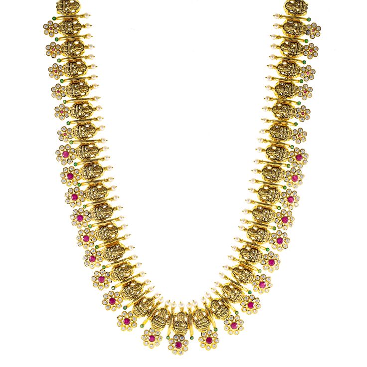 This 22k antique gold temple necklace from Virani Jewelers captures the beauty of Indian jewelry with its intricate craftsmanship and vibrant gemstones. Rubies, emeralds, and cubic zirconia create a stunning focal point, set against the rich hues of antique 22k gold. Whether worn for formal gatherings or cultural celebrations, this necklace adds a refined touch to any outfit. A statement of both elegance and tradition, it’s the perfect addition to a sophisticated jewelry collection.Features• 22k Gold Temple Necklace, Temple Necklace, Sophisticated Jewelry, Cultural Celebration, Antique Finish, 22k Gold, Indian Jewelry, Antique Gold, Focal Point