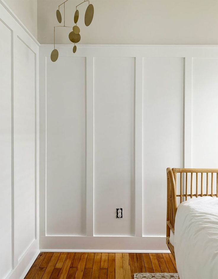 a bedroom with white walls and wooden floors