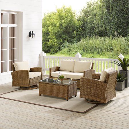 an outdoor living room with wicker furniture