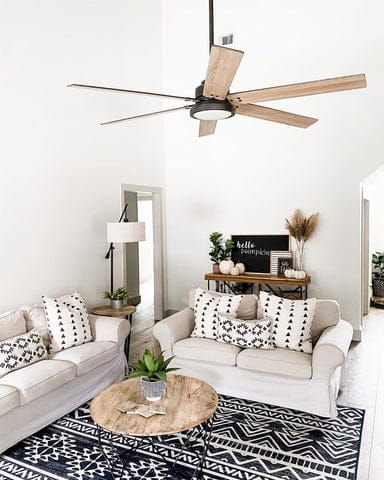 a living room with two couches and a ceiling fan in the middle of it