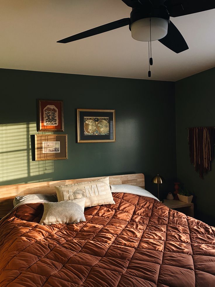 a bedroom with a bed, ceiling fan and pictures on the wall