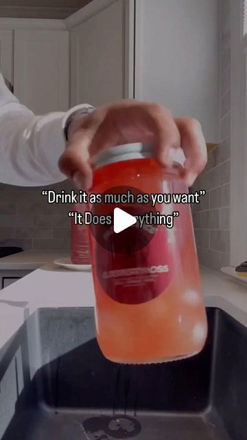 a person is pouring something into a sink with a red canister in front of them