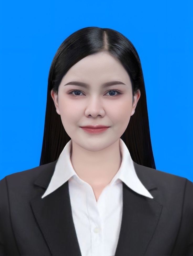 a woman with long black hair wearing a white shirt and black blazer, standing in front of a blue background