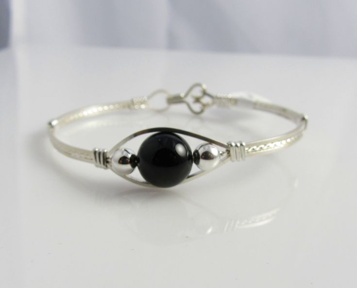 This beautiful bangle is handmade with a 10mm Black Onyx Gemstone, two sterling silver beads and is wire wrapped with argentium sterling silver wire. It is a fun bracelet and looks lovely on the wrist. To get the perfect fit, measure your wrist and add one half inch. Handmade Onyx Round Bracelets, Handmade Onyx Bracelets, Handmade Onyx Round Bracelet, Black Sterling Silver Round Bracelet Gift, Black Onyx Bracelet, Fun Bracelet, Swarovski Crystal Bracelet, Swarovski Bracelet, Wire Wrapped Bracelet