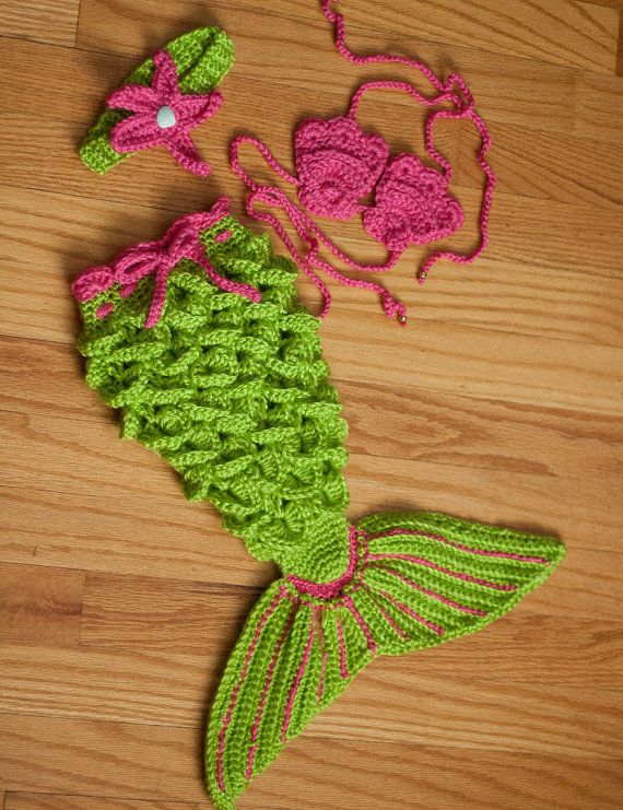 a crocheted mermaid tail and matching hat are on the floor next to each other