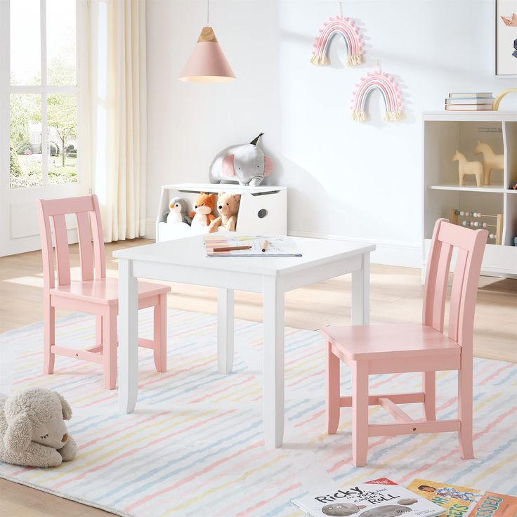 a child's table and two chairs in a room with toys on the floor