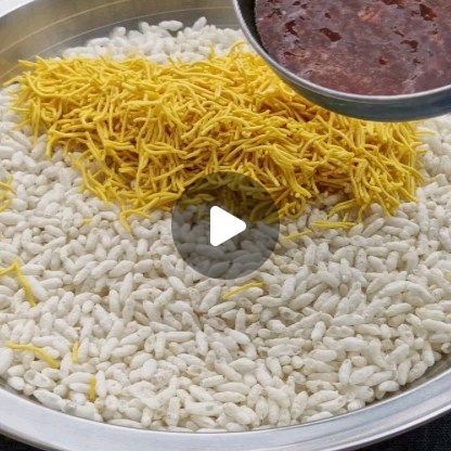 a bowl filled with rice and sauce on top of a metal tray next to a spoon