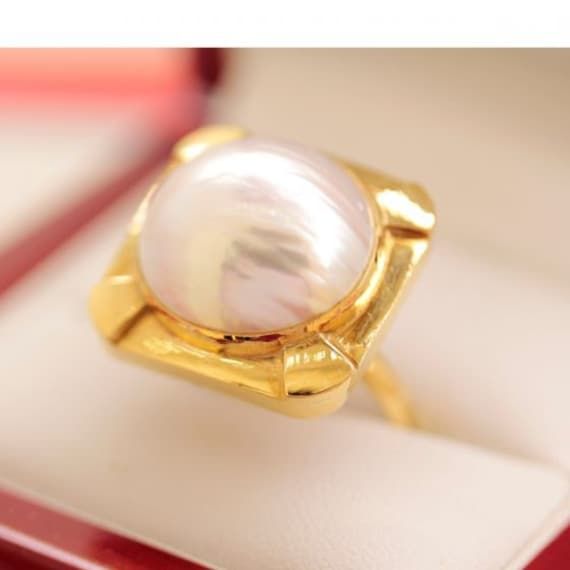 "A Vintage Cocktail ring with Mabe Pearl center for women, Pearl in 22k gold ring, Stunning 1960's ring for women. One ladies handmade 22ct yellow gold dress ring, narrow, half round, parallel shank rub-over setting, polished finish, stamped (22CT). The item contains: One rub over set semi-round maybe white pearl, luster is \"High\", good matching, with a rose overtone. Dimensions = 16.33mm(L) x 16.31mm(W) x 11.75mm(D) Item Totals: Total Item Weight = 10.60gm" Elegant Yellow Gold Cabochon Diamond Ring, Anniversary Yellow Gold Cabochon Diamond Ring, Classic Gold Cabochon Diamond Ring, Timeless Oval Rings With High Luster, Classic Gold Diamond Ring With Cabochon, Gold Cabochon Diamond Ring Fine Jewelry, Formal Yellow Gold Pearl Ring With High Luster, Timeless Gold Dome Ring With Cabochon, Formal Yellow Gold Rings With High Luster