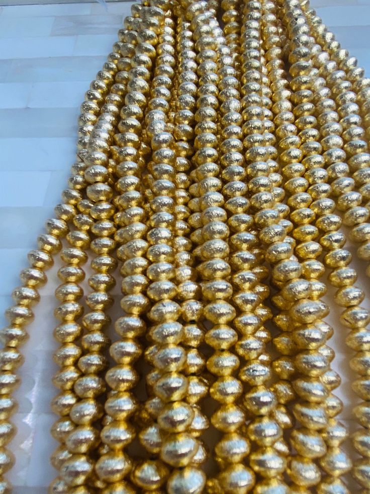 gold colored beads are lined up on the table