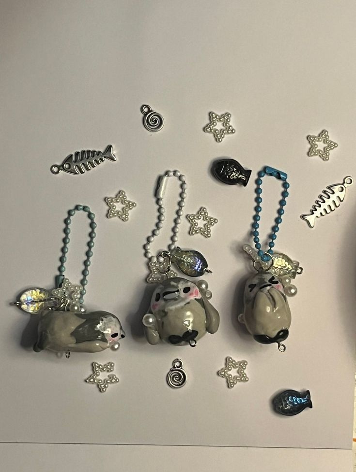 several charms are hanging on the wall next to a clock and keychain,