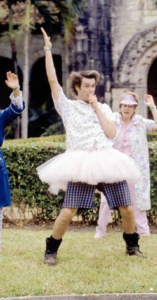 two people dressed in costumes are dancing on the grass with one person holding his hand up