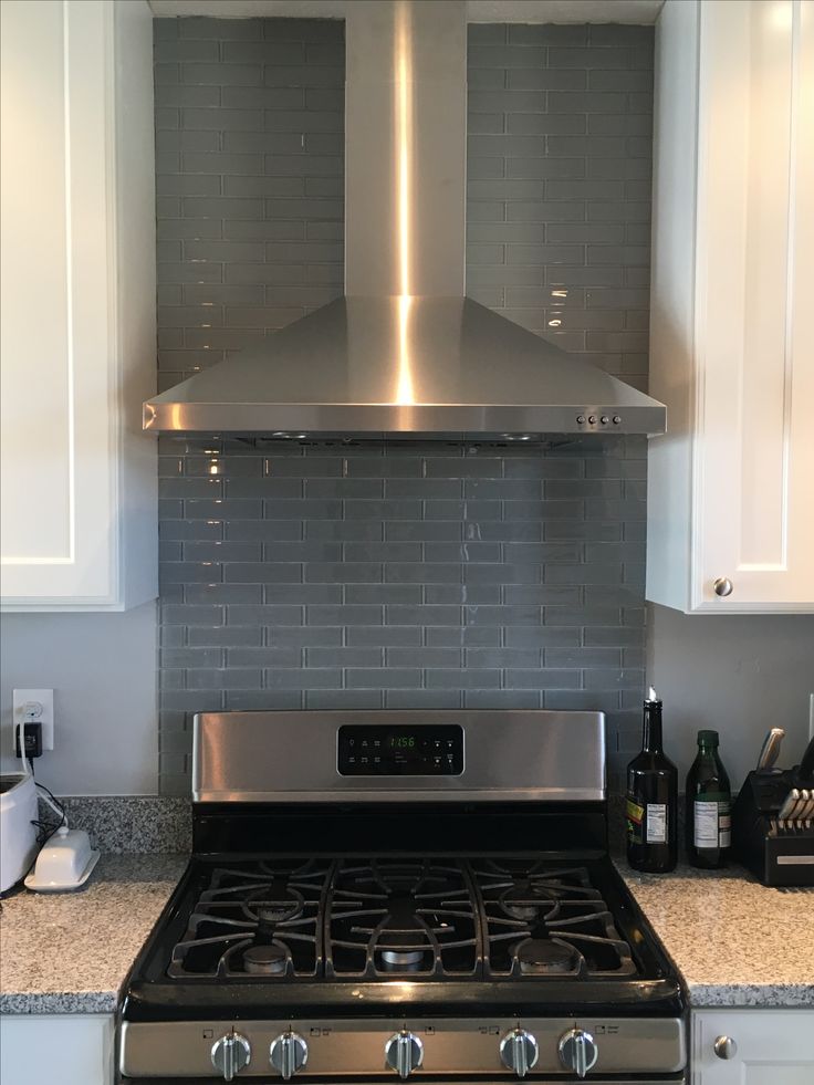 a stainless steel stove top oven sitting in a kitchen next to white cabinets and counter tops