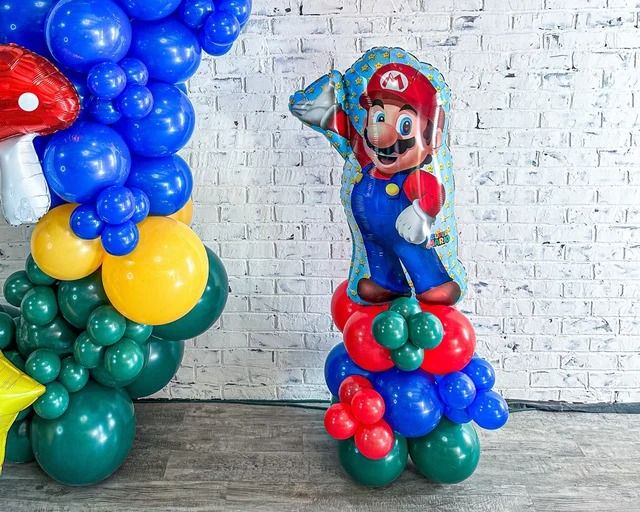 some balloons are stacked on top of each other in front of a white brick wall