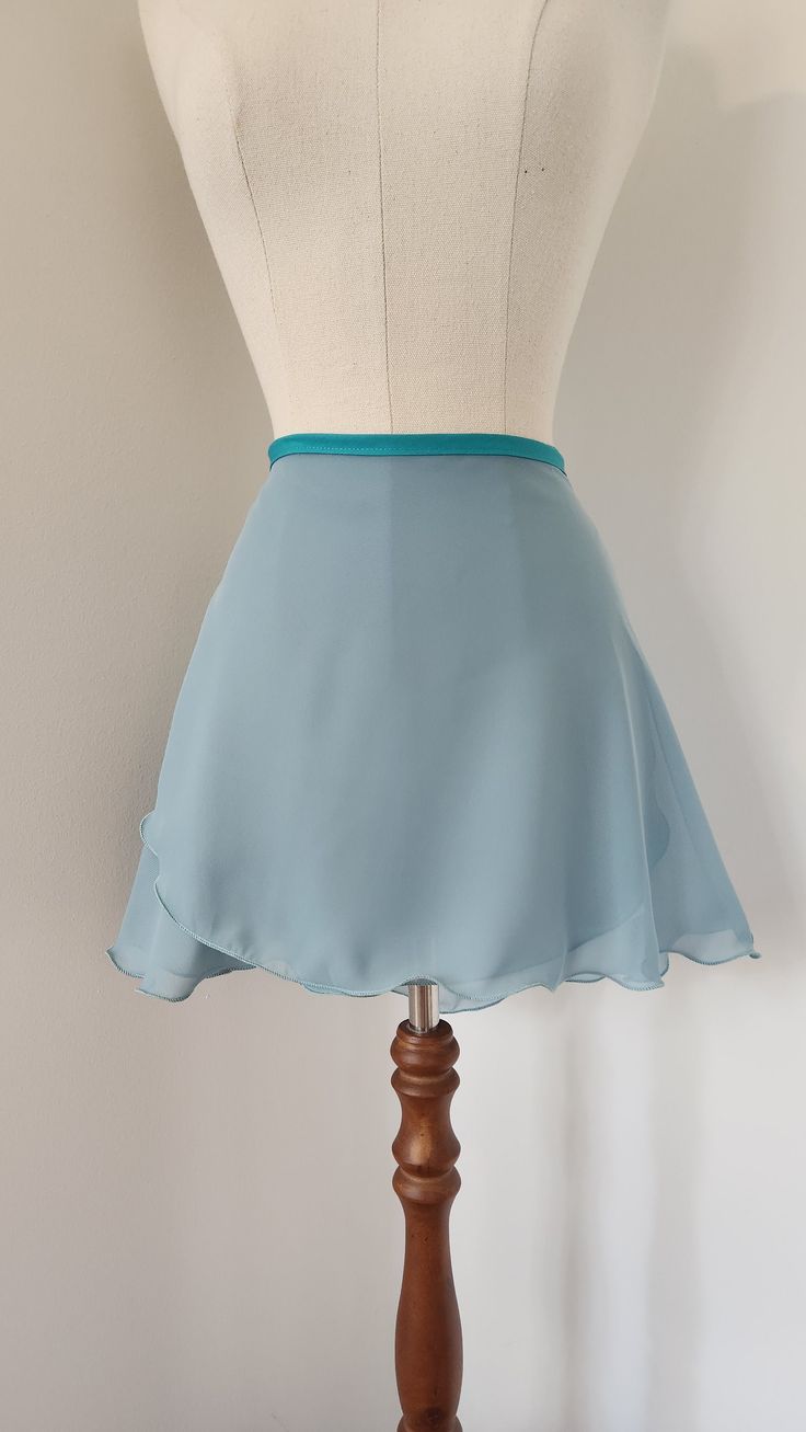 Handmade ballet wrap skirt, a distinctive muted teal chiffon with contrasting poly cotton tie waistband. Available in a range of lengths for the perfect fit. The semi opaque fabric is ideal to show correct alignment while still giving enough coverage for modesty.  Sizing: For measurements on the cusp of sizes, we recommend the larger size for larger crossover and more modest coverage. The shape and size of the Demi, Eleve, and Rond Curve range are designed specially for curvy dancers with a long Fitted Blue Asymmetrical Wrap Skirt, Fitted Blue Elegant Wrap Skirt, Blue Fitted Lined Wrap Skirt, Fitted Blue Lined Wrap Skirt, Fitted Blue Flared Wrap Skirt, Fitted Flared Blue Wrap Skirt, Fitted Chiffon Mini Skirt, Ballet Wrap Skirt, Long Cut