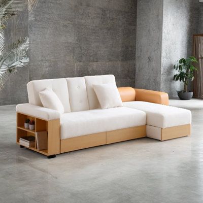 a white couch sitting on top of a cement floor next to a potted plant