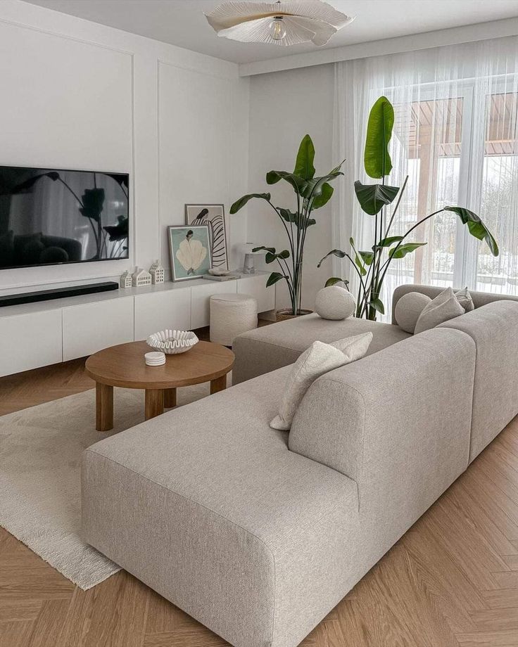 a living room filled with furniture and a flat screen tv mounted to the side of a wall