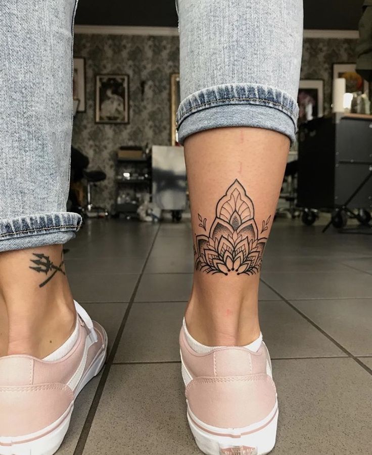 a woman's foot with a tattoo on her left leg and the bottom part of her legs