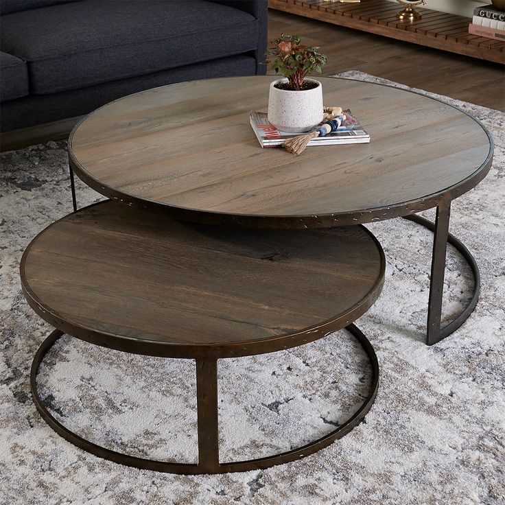 two tables sitting on top of a rug in a living room next to a couch