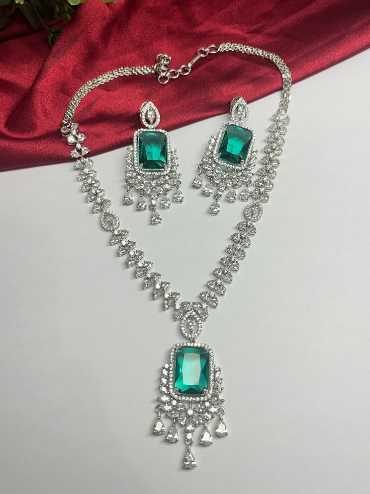 Gorgeous fine quality imitation jewellery  CZ  Teal color with CZ diamonds studded necklace with white gold rhodium plating and matching Earrings Item contains: Necklace and earrings AAA quality cubic zirconia used. Highest quality and craftsmanship Necklace Fitting is adjustable Earrings Closure: Pushback Necklace Closure: chain with Hook Details-  -Handmade item -Delivery from a small business in India -Materials: white rhodium, stones, cz, zircon, American diamond -Jewellery type: Earrings, N Green Diamond Bridal Necklace In Fine Jewelry Style, Fine Jewelry With Green Diamond Cut, Silver Emerald Jewelry With Diamond Accents, Silver Emerald Jewelry Sets With Elegant Design, Fine Jewelry With Elegant Green Design, Green Fine Jewelry With Elegant Design, Silver Emerald Jewelry Sets For Anniversary, Elegant Silver Jewelry Sets With Emeralds, Dazzling Green Jewelry Sets For Anniversary