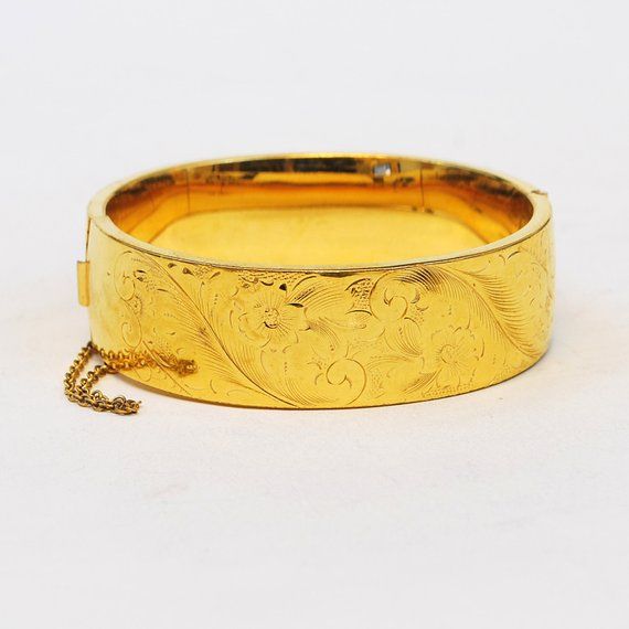 This antique 1920's hand engraved gold filled bangle bracelet is just gorgeous.  This bracelet is big and bold but has dainty little flowers engraved and will really make a statement on your wrist.  Hinged for easy on and off, it also contains a safety clasp for added security.  Antique Bracelet1920'sGold FilledDimensions: Inside diameter is 7" and the width is 3/4"Please read our shop policies prior to purchase. Thanks for looking and contact us with any questions. Antique Gold Bracelet Stamped 14k, Antique 14k Stamped Gold Bracelet, Antique 14k Stamped Bangle As Gift, Classic Engraved Bangle For Ceremonial Occasions, Antique Yellow Gold Bangle For Formal Occasions, Classic Ceremonial Engraved Bangle, Vintage Yellow Gold Bangle Stamped 14k, Classic Gold Etched Bangle, Ceremonial Engraved Yellow Gold Bracelet