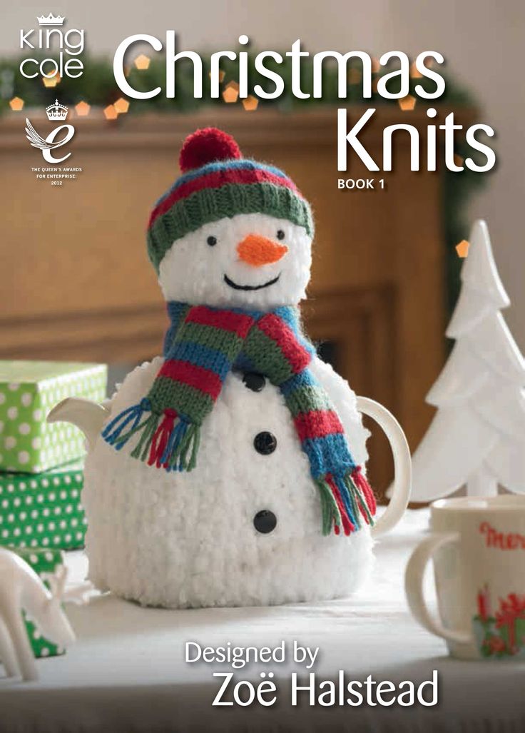 a knitted snowman sitting on top of a table next to a cup and saucer