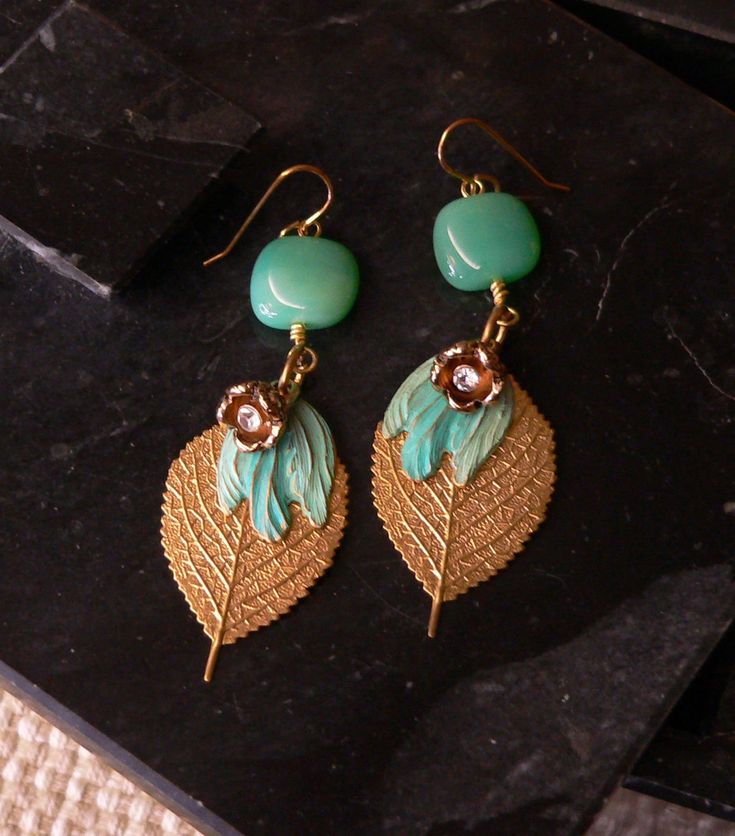 "earring, flower earring, green earring, green and gold, flower charm, leaf charm, boho earring, boho chic, bohemian, cute earring, gift Bold dangle earrings start with green czech glass beads and finish with a dangle of flower charm, green patinaed petals and gold toned leafs.  3 1/8\" length from top of gold toned earwire.   Buy 3 pair earrings and get 20% off your purchase.  Enter coupon code 3PAIREARRINGS" Green Brass Earrings Nature-inspired, Green Flower Charm Drop Earrings, Nature-inspired Green Dangle Flower Earrings, Green Bohemian Flower Shaped Jewelry, Handmade Green Flower Drop Earrings, Bohemian Green Flower Charm Earrings, Green Flower-shaped Nature-inspired Earrings, Nature-inspired Green Flower Earrings, Green Dangle Jewelry With Flower Charm